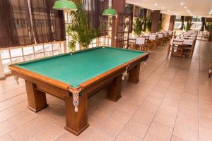 a pool table in a room with tables and chairs at Stratus Vila Hotel in Volta Redonda