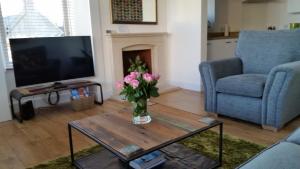 una sala de estar con un jarrón de flores sobre una mesa de centro en Tighnabruaich Annex en Lossiemouth