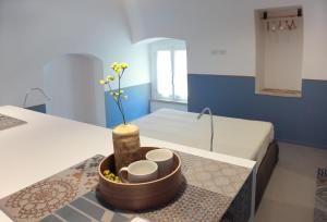 a room with a table with a vase with flowers in it at Piano Piano - Rooms in Matera