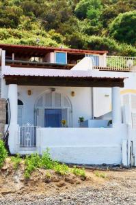 Casa blanca con porche y valla en Casa Canale Lipari, en Canneto