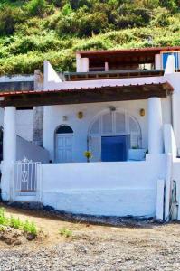 a blue and white house with a white wall at Casa Canale Lipari in Canneto