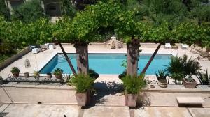 uma piscina com árvores e vasos de plantas em B&B Posserle em Padenghe sul Garda