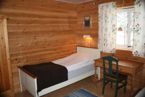 a bedroom with a bed and a desk and a chair at Årrenjarka Mountain Lodge in Kvikkjokks Kapell