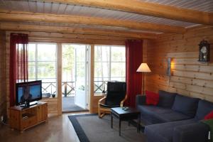 a living room with a couch and a tv at Årrenjarka Mountain Lodge in Kvikkjokks Kapell