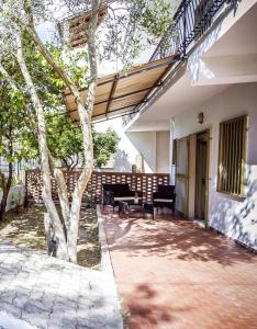 a porch of a house with a tree at La Via Del Mare in Palinuro