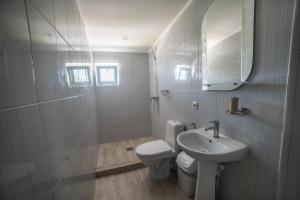 a white bathroom with a toilet and a sink at Alkatraz in Gribovka +104 photos