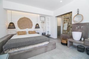 a bedroom with a large bed and a bath tub at Malibu Boutique Studios & Bungalows in Faliraki
