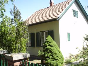 a small white house with a tree in front of it at Oázis Vendégház in Gyula