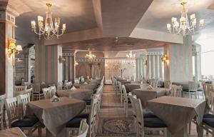 a dining room with tables and chairs and chandeliers at Chaika Beach Resort in Sunny Beach