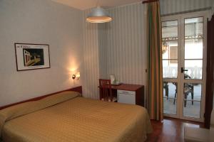Schlafzimmer mit einem Bett und einer Glasschiebetür in der Unterkunft Il Forno Dal 1922 in Bene Vagienna