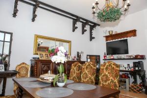 a dining room with a table and chairs and a television at IL Piccolo Castello Busteni in Buşteni