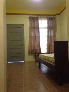 a bedroom with a bed and a window and a door at Brown Epitome Lodge in Baler