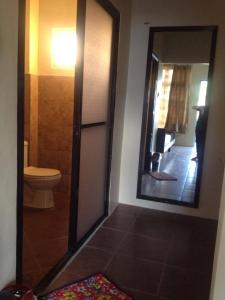 a bathroom with a toilet and a large mirror at Brown Epitome Lodge in Baler