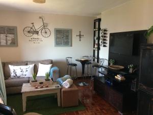 a living room with a couch and a bike on the wall at Swartkops River Retreat in Port Elizabeth
