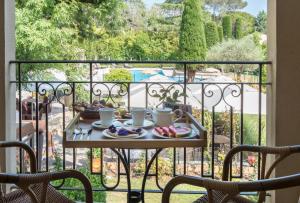 a table with plates of food on a balcony at Hôtel De Mougins in Mougins