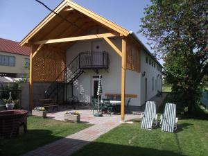 un padiglione con due sedie e un tavolo in un cortile di Radek Vendégház és Apartman a Halászi