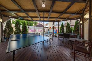 a ping pong table on a deck with chairs at Hotel Olivia Anapa in Anapa