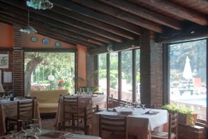 a restaurant with tables and chairs and a large window at Agriturismo Fattoria di Grenne in Ficarra