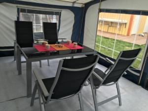 a table and two chairs in front of a tent at Irjados-surf in Chałupy