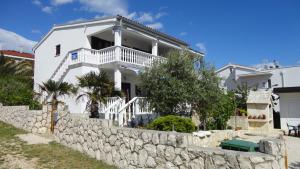 a white house with a stone wall at Apartments Lora in Vir