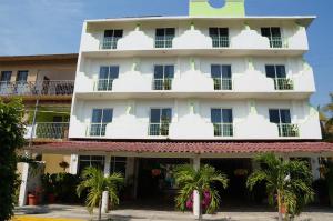 a building with palm trees in front of it at Hotel Arenas del Pacifico in Santa Cruz Huatulco