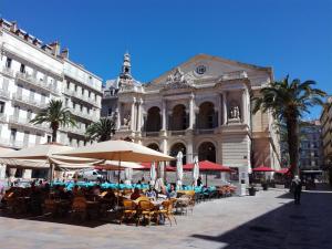 a group of tables and umbrellas in front of a building at Studio Toulon les Halles in Toulon