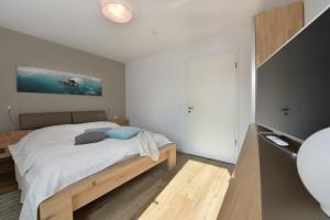 a bedroom with a bed with white sheets and blue pillows at Wassermusik in Juliusruh