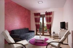 a living room with a couch and a tv at Myriam Spa & Luxury Suites in Monemvasia