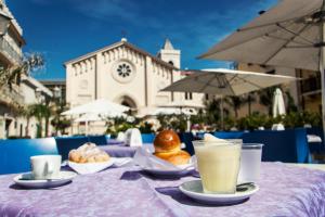 a table with a purple table cloth with drinks and pastries at Polifemo in Letojanni