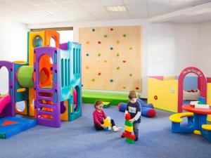 dos niños jugando en una sala de juegos con equipo de juego en Ferienresidenz Raich, en Ried im Oberinntal