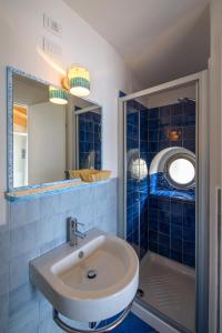 a blue tiled bathroom with a sink and a shower at Le poste di Simplicio in Campese