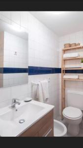 a white bathroom with a toilet and a sink at Apartamento Minerva Jupiter. The perfect accommodation for your vacation in Benalmádena