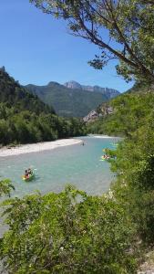 eine Gruppe von Menschen in Booten in einem Fluss in der Unterkunft Les Acacias in Vercheny