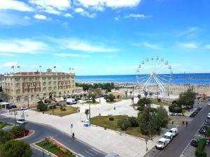 a city with a ferris wheel in front of the ocean at Hotel Residence Adriana in Cesenatico