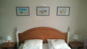 a bedroom with a bed with three pictures on the wall at Haus Strandeck Apartment Meeresrauschen 10 in Göhren