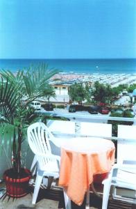 un tavolo e sedie su un balcone con vista sulla spiaggia di Hotel Rivamare a Cervia