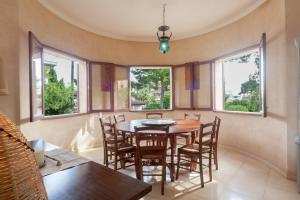 a dining room with a table and chairs and windows at Can Xim in Cala Millor