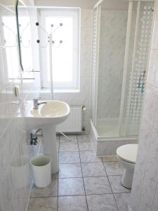 a white bathroom with a sink and a toilet at Klocek in Mrzeżyno