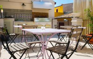 un tavolo rosa e sedie su un patio di B&B Casa Liuzza a Santa Teresa di Riva