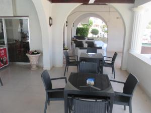 a restaurant with tables and chairs and an archway at Tsialis Hotel Apartments in Larnaca