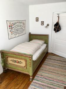 a bed in a room with a rug and a door at Landhaus Hallstättersee in Bad Goisern