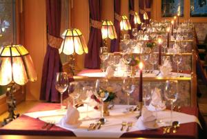 uma mesa com copos de vinho e flores em Hotel Rustika em Lermoos