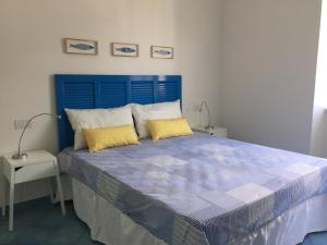 a blue bed with two yellow pillows in a bedroom at Casa Sole in Minori