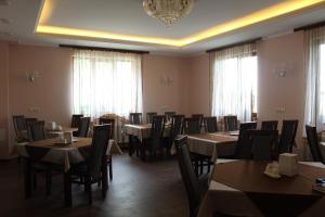 a dining room with tables and chairs and a chandelier at Sukhoviia in Yasinya