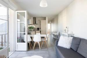 a living room and kitchen with a couch and a table at Sweet Apartment in Saint Malo