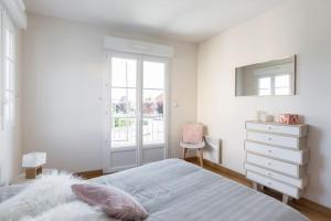 a bedroom with a bed and a dresser and a window at Sweet Apartment in Saint Malo