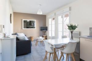 a kitchen and living room with a white table and chairs at Sweet Apartment in Saint Malo