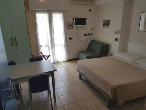 a bedroom with a bed and a desk and a chair at Hotel Residence Adriana in Cesenatico +31 photos
