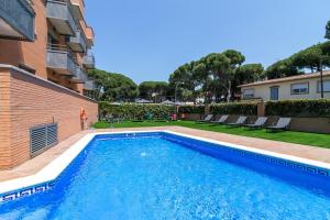 a swimming pool in front of a building at Aparthotel Bardon in Castelldefels