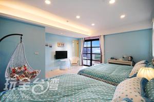 a blue bedroom with two beds and a television at Sea People B&B in Magong